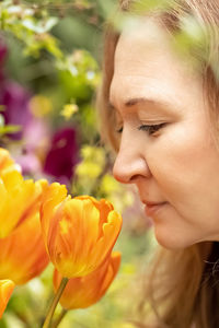 A middle-aged woman sniffs and admires tulips in the botanical garden.spring.