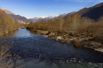 Scenic view of river amidst snowcapped mountains against sky