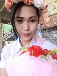 Portrait of smiling woman holding flower bouquet