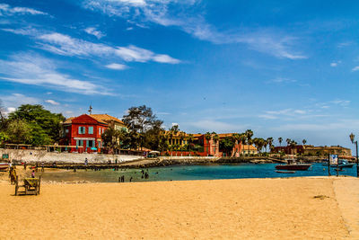 Houses by sea against sky