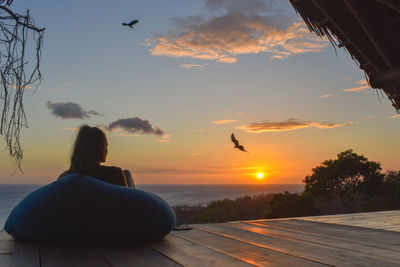 Woman relaxing at beach during sunset