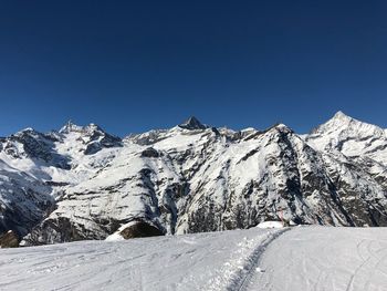 Snowcapped mountains against clear blue sky