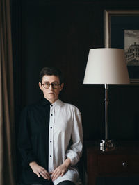 Portrait of young man standing against wall