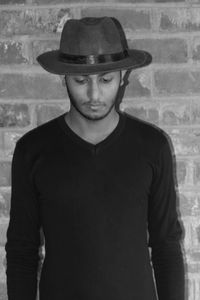 Portrait of young man standing against wall