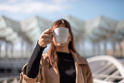 Midsection of woman drinking coffee