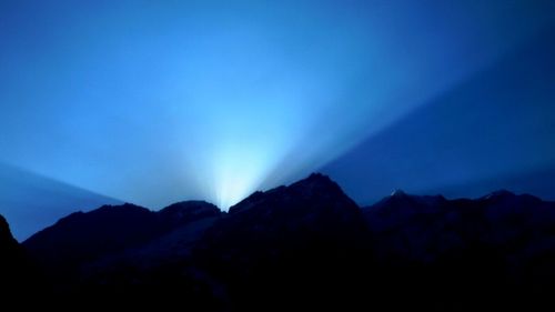 Scenic view of silhouette mountains against sky at night