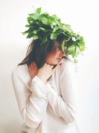 Close-up of young woman against white background