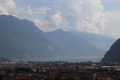 Aerial view of townscape by mountains against sky