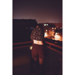 Rear view of woman standing against window