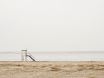 Lifeguard hut at beach against sky