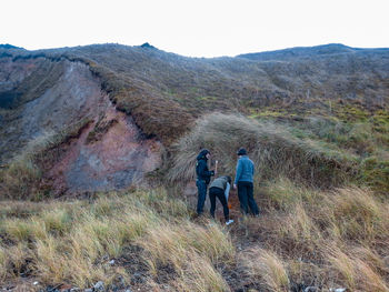 Rear view of people on mountain against sky