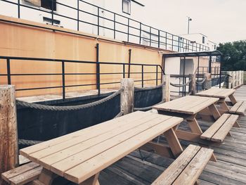 Empty chairs and tables against built structure