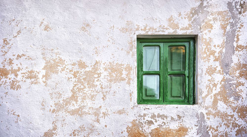 Green window on weathered wall