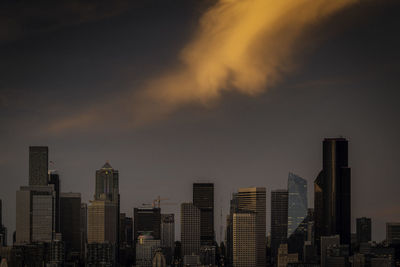 Modern buildings in city against sky during sunset