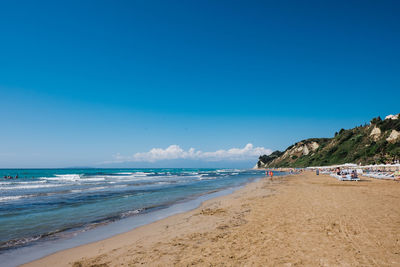 Scenic view of beach against blue sky