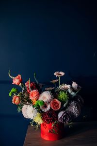 Close-up of flower decorations on table against daek blue wall in a smooth wintery light