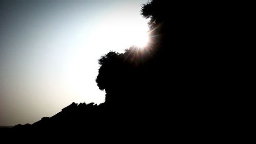 Low angle view of silhouette trees against clear sky
