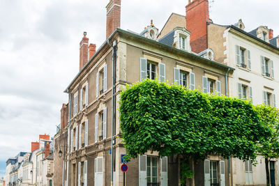 Low angle view of building and trees against sky