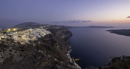Rocky mountain by sea against sky during sunset in fira