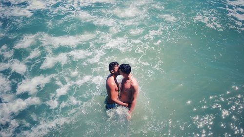 High angle view of shirtless man in sea