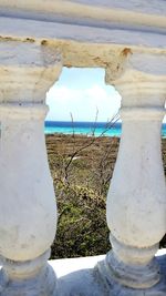 Close-up of stone wall by sea against sky