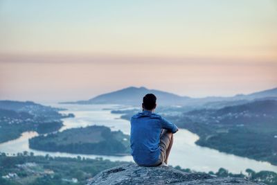 Rear view of man on mountain against sky