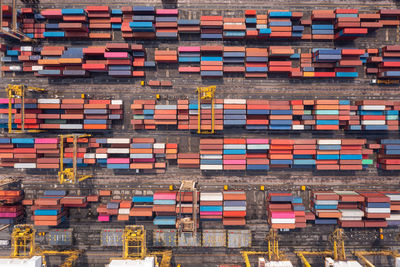 Warehouse stacking containers group in a row and cranes load unloading, distribution center 