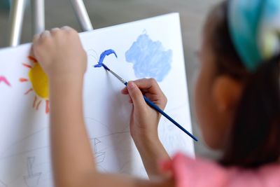 Close-up of girl painting on canvas