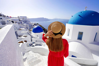 Vacation in greece. beautiful tourist girl enjoying panoramic view of santorini. wide angle.