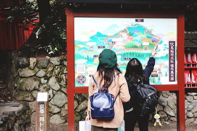 Rear view of woman looking at map