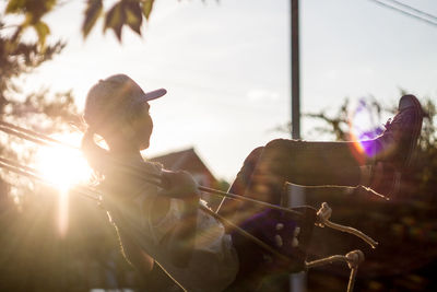 Close-up of man holding tree against sky