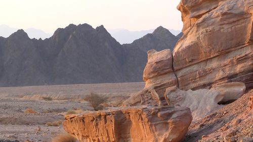 View of rock formations in desert at sunrise 