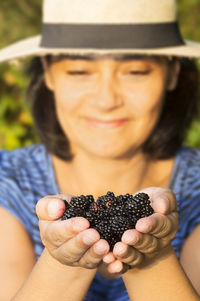Happy mid adult woman holding mulberries