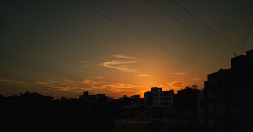 Silhouette buildings against sky during sunset