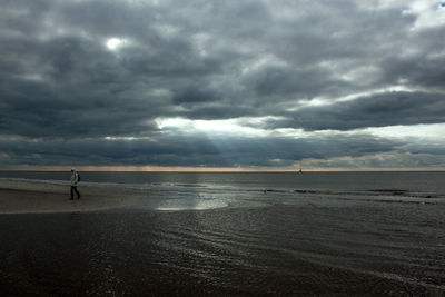 Scenic view of calm sea against cloudy sky