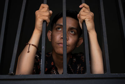 Portrait of young man with reflection on window