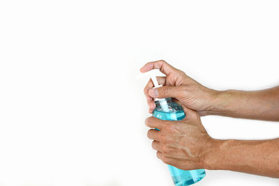 Close-up of hand holding paper over white background