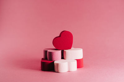 Close-up of heart shape on pink fabric against red background