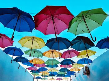 Low angle view of umbrellas hanging against sky