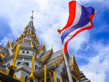 Low angle view of flags on building against sky