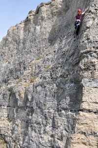 Low angle view of man rock climbing