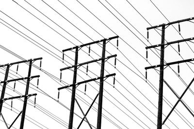 Low angle view of electricity pylon against clear sky