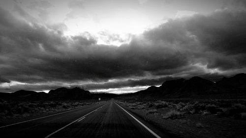 Country road against cloudy sky