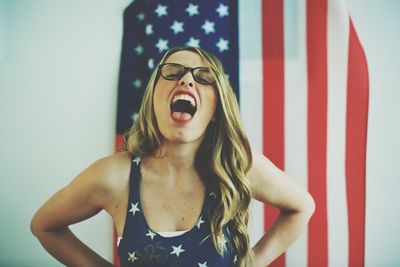 Portrait of woman with mouth open against american flag