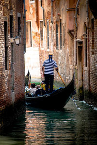 Man standing on boat in canal