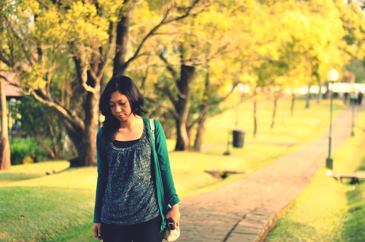 lifestyles, person, young adult, casual clothing, tree, looking at camera, front view, portrait, leisure activity, standing, smiling, young women, focus on foreground, three quarter length, outdoors, park - man made space