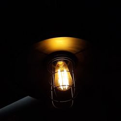 Close-up of illuminated light bulb in darkroom