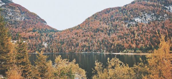 Scenic view of lake by mountains during autumn