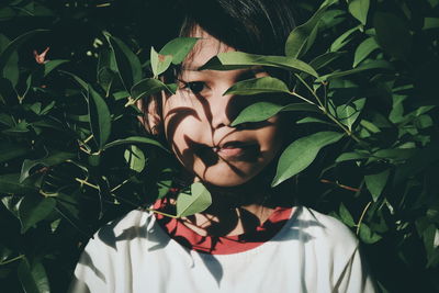 Portrait of girl standing by plants