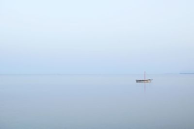 Boat sailing on sea against sky during foggy weather